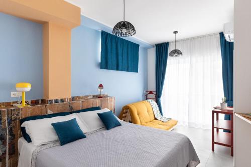 1 dormitorio con paredes azules, 1 cama y 1 silla en FRESHWATER PIRATES, en Gaeta