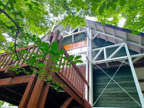 eine Holztreppe, die zu einem Gebäude mit Bäumen führt in der Unterkunft S-villa Nasu Candy in Nasu
