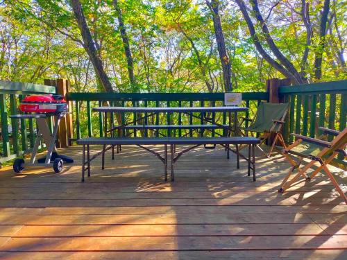 eine Bank und zwei Stühle auf einer Holzterrasse in der Unterkunft S-villa Nasu Candy in Nasu