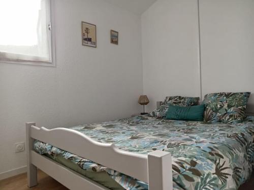 Ce lit se trouve dans une chambre blanche dotée d'un canapé-lit. dans l'établissement Jolie maisonnette dans résidence calme avec piscine, au Barcarès