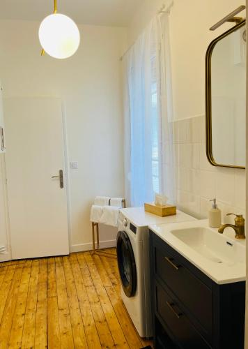une salle de bain avec une machine à laver et un lavabo dans l'établissement Appartement Porte Mars 1 Reims Arena gare centre, à Reims
