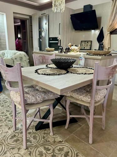 a dining room table with two chairs and a kitchen at Speranza's Sweet Home in Vrontados