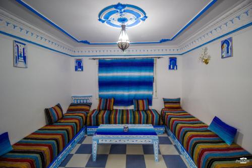a living room with two couches and a table at Casa Voyager 'secret garden terrace' in Chefchaouene