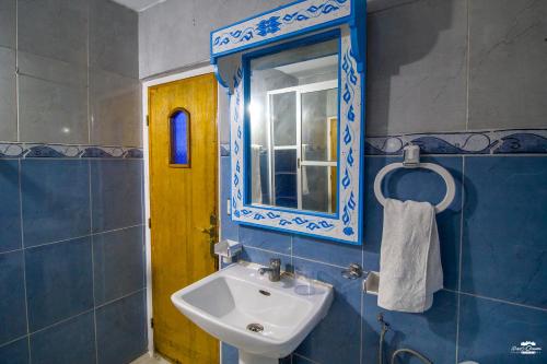 a bathroom with a sink and a mirror at Casa Voyager 'secret garden terrace' in Chefchaouen