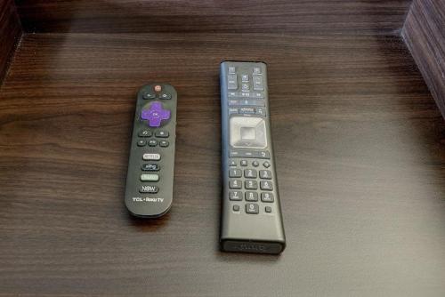 two remote controls sitting on top of a table at Modern Twist In A Historic Building, Sleeps 6 in Atlanta