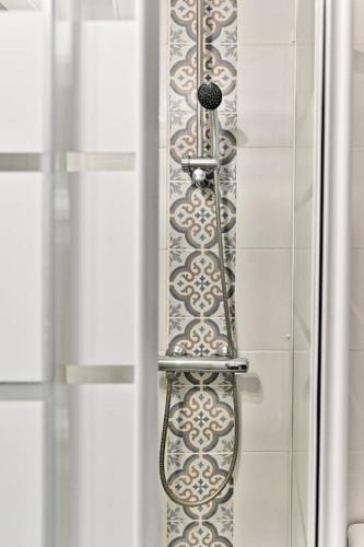 - un rideau de douche dans la salle de bains pourvue d'une porte en verre dans l'établissement Appartement cosy face de Paris Montparnasse, à Paris