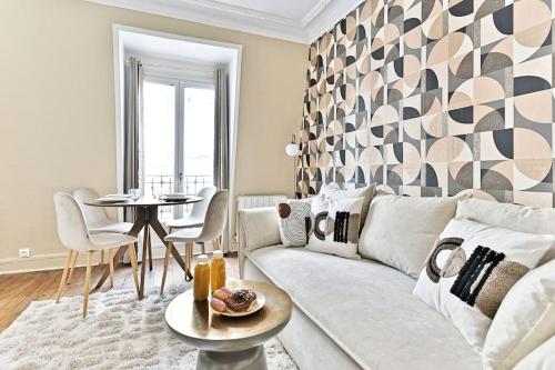 un salon avec un canapé blanc et une table dans l'établissement Appartement cosy face de Paris Montparnasse, à Paris
