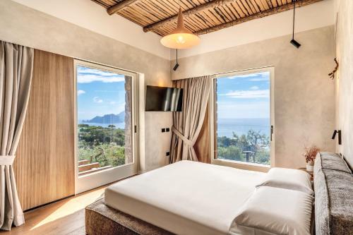 a bedroom with a bed and a large window at Casale La Torre Luxury by Feeling Italy in Massa Lubrense
