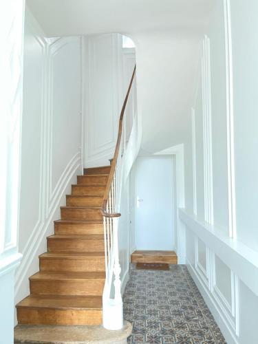 a staircase in a home with white walls and wood floors at Appartement Porte Mars 1 Reims Arena gare centre in Reims