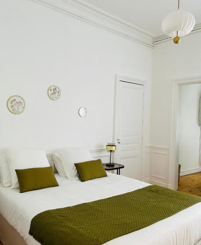 - une chambre blanche dotée d'un grand lit avec des draps verts dans l'établissement Appartement Porte Mars 1 Reims Arena gare centre, à Reims