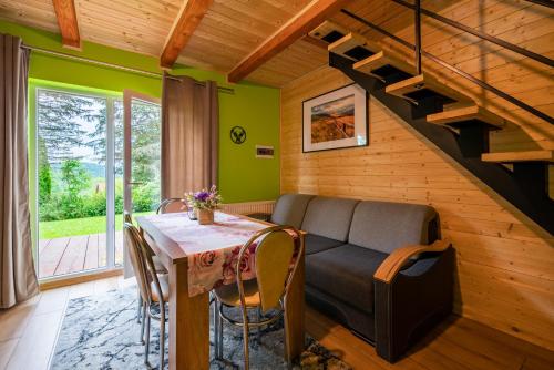 a living room with a couch and a table at AgroOsada u Beatki - Sauna & Jacuzzi in Lutowiska