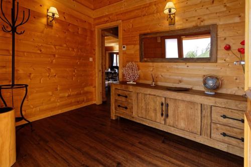 a log cabin living room with a sink and a window at Chalet d'exception, spa et sauna, 4p in La Bresse