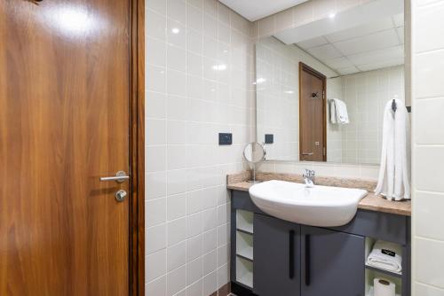 a bathroom with a sink and a mirror at Emirates Sports Hotel, Dubai Sports City in Dubai