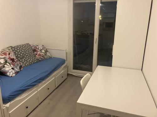 une petite pièce avec un lit et une table dans l'établissement Studio cosy avec jardin proche lac et métro, à Créteil
