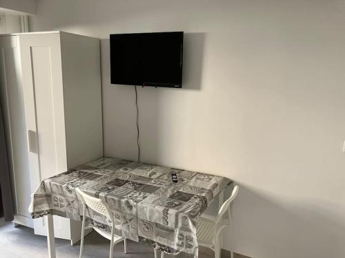 une pièce avec une table et une télévision sur un mur dans l'établissement Studio cosy avec jardin proche lac et métro, à Créteil