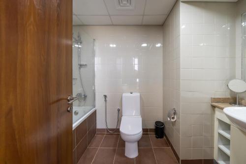 a bathroom with a toilet and a shower and a sink at Emirates Sports Hotel, Dubai Sports City in Dubai