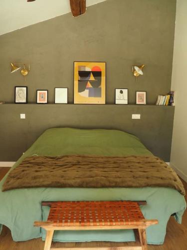 - une chambre avec un lit et un banc dans l'établissement Charmante Grange aux Monts d'Or, à Collonges-au-Mont-dʼOr