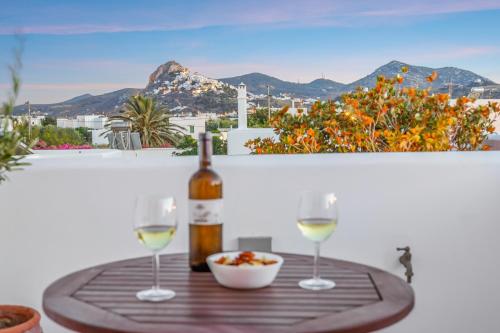 a table with a bottle of wine and two glasses at Anemonisia Skyrian Living in Skiros