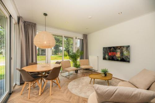 a living room with a table and chairs at Vakantiepark Buitenplaats Holten in Rijssen
