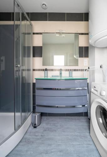 une salle de bain avec un lavabo bleu et un miroir dans l'établissement Résidence Le Celest - Appartements climatisés - Centre ville, à Vichy