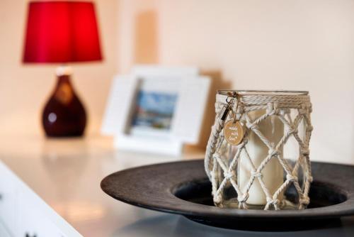 a glass mug sitting on a plate on a table at Sabines Ferienwohnung in Glückstadt