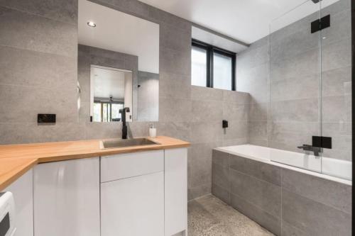 un baño con lavabo y bañera en Chic Beach Studio, en Rye