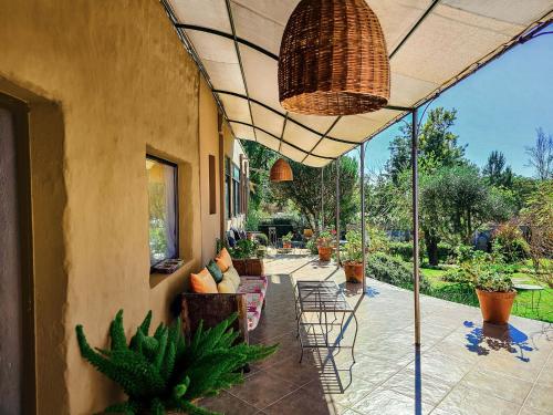 an outdoor patio with chairs and potted plants at Bo Hotel & Spa Chicoana Salta in Chicoana