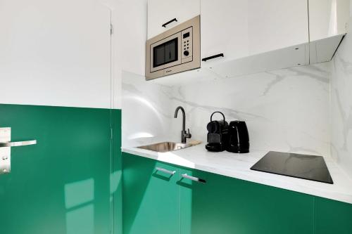 une cuisine avec un évier et un micro-ondes dans l'établissement Cosy Cocoon for 2P with A-C - Near Montmartre, à Paris