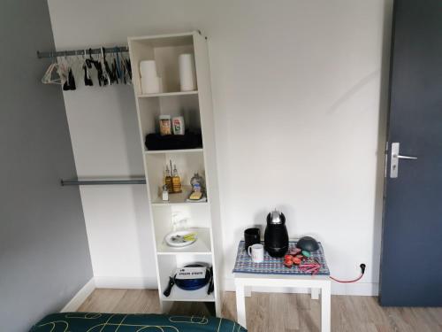 a room with a white shelf with a table at Chambre cœur du centre-ville in Le Havre