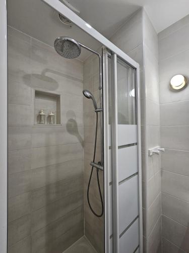 une douche avec une porte vitrée dans une salle de bain dans l'établissement Beautiful 1 Bedroom Flat in Paris 17th, à Paris