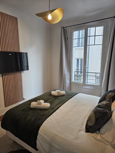 une chambre avec un grand lit avec deux serviettes dessus dans l'établissement Beautiful 1 Bedroom Flat in Paris 17th, à Paris