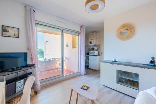 Il comprend un salon avec une grande fenêtre et une cuisine. dans l'établissement Appartement Vistamare - Welkeys, à Bandol