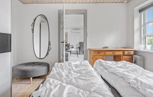 a bedroom with a bed and a mirror and a chair at 1 Bedroom Amazing Home In Stubbekøbing in Stubbekøbing