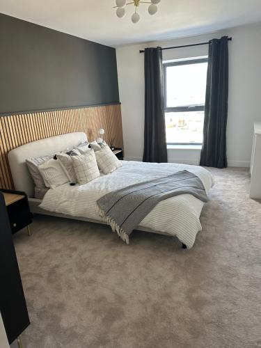 a bedroom with a large bed and a window at Ocean Breeze Apartment in Portrush