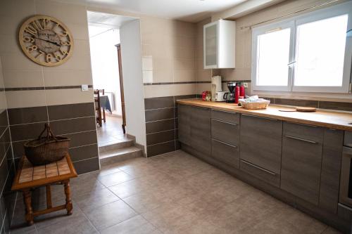 a kitchen with a large clock on the wall at Retrouvailles de famille et amis 3 étoiles in Lucy-sur-Cure