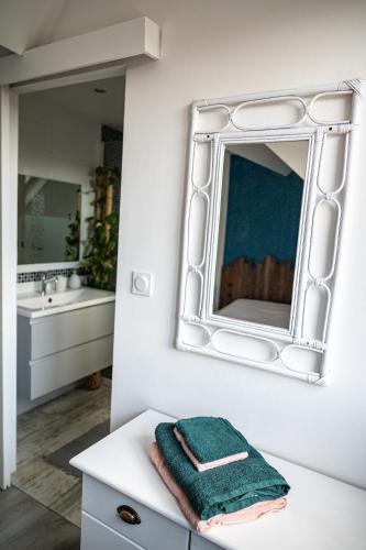 a bathroom with a mirror and a green towel on a counter at Retrouvailles de famille et amis 3 étoiles in Lucy-sur-Cure