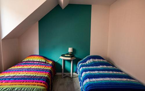 two beds in a room with a green wall at Retrouvailles de famille et amis 3 étoiles in Lucy-sur-Cure