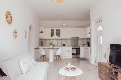 a living room with a white couch and a kitchen at Mylos Home in Analipsi