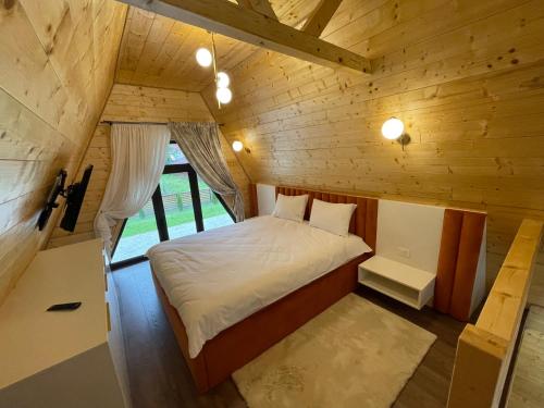 a bedroom with a bed in a wooden cabin at Casa Belvedere Pietrosu in Moisei