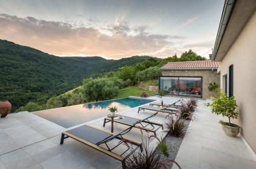 a house with a swimming pool with mountains in the background at Villa Horto in Livade