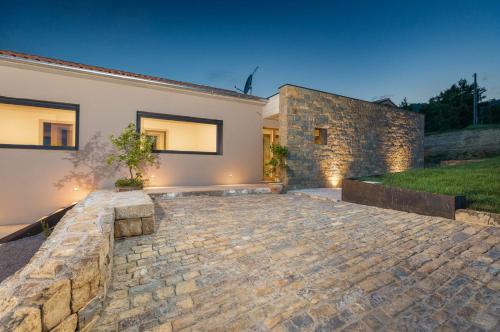 a house with a stone driveway in front of it at Villa Horto in Livade