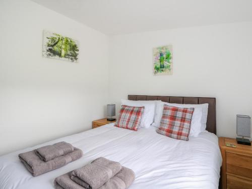 Un dormitorio con una cama blanca con dos almohadas. en 6 Strathtay Lodges, en Aberfeldy