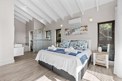 a bedroom with a large bed and a bathroom at San Lameer Villa - 14306 - 5 Bedroom Luxury - 10 pax - San Lameer Rental Agency in Southbroom