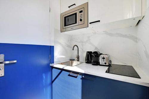 une petite cuisine avec un évier et un micro-ondes dans l'établissement Studio Cosy for 2P with A-C - Near Montmartre, à Paris