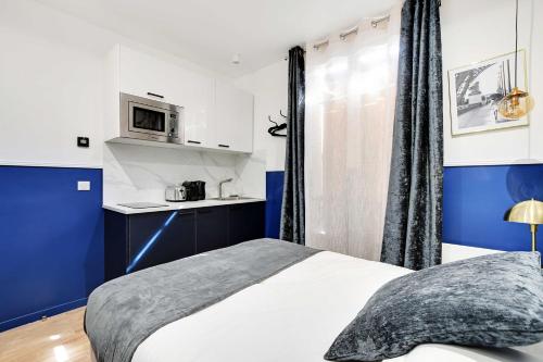 Il comprend une chambre avec un lit et une cuisine équipée d'un four micro-ondes. dans l'établissement Charming Studio - 2P with AC Near Montmartre, à Paris