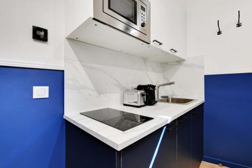 une cuisine avec un évier et un micro-ondes dans l'établissement Charming Studio - 2P with AC Near Montmartre, à Paris