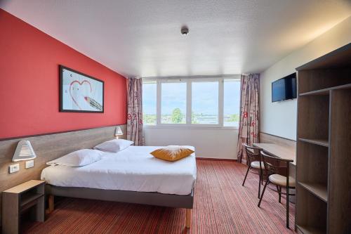 a hotel room with a bed and a desk at Ace Hôtel Caen Nord Mémorial in Caen