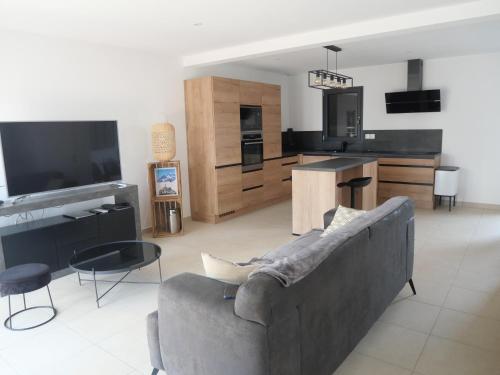 un salon avec un canapé et une cuisine dans l'établissement Maison pour 5 personnes, à Garons