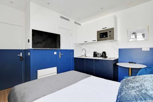 - une chambre bleue et blanche avec un lit et un lavabo dans l'établissement Modern Sutdio for 2 with A-C - Near Montmartre, à Paris