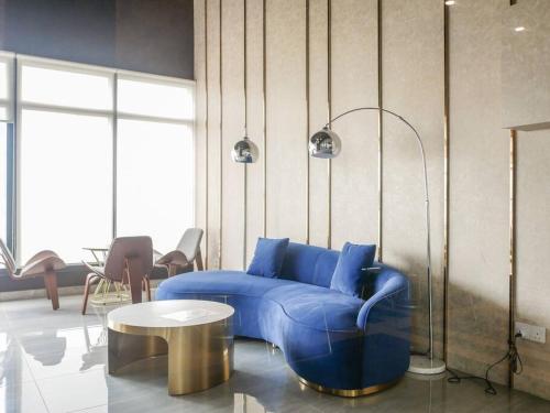 a living room with a blue couch and a table at Comfort 3 Bedroom Urban Suite by Uptrend Home Management in Jelutong